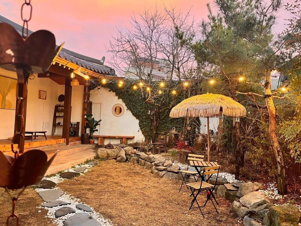 a patio with an umbrella and a table and chairs at Jeonju Sosohanhanok in Jeonju