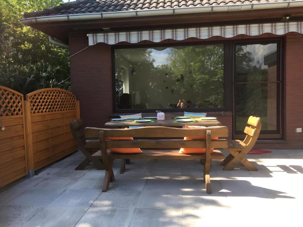a wooden table and two chairs on a patio at Ferienhaus Kribbikrabba Butjadingen in Butjadingen