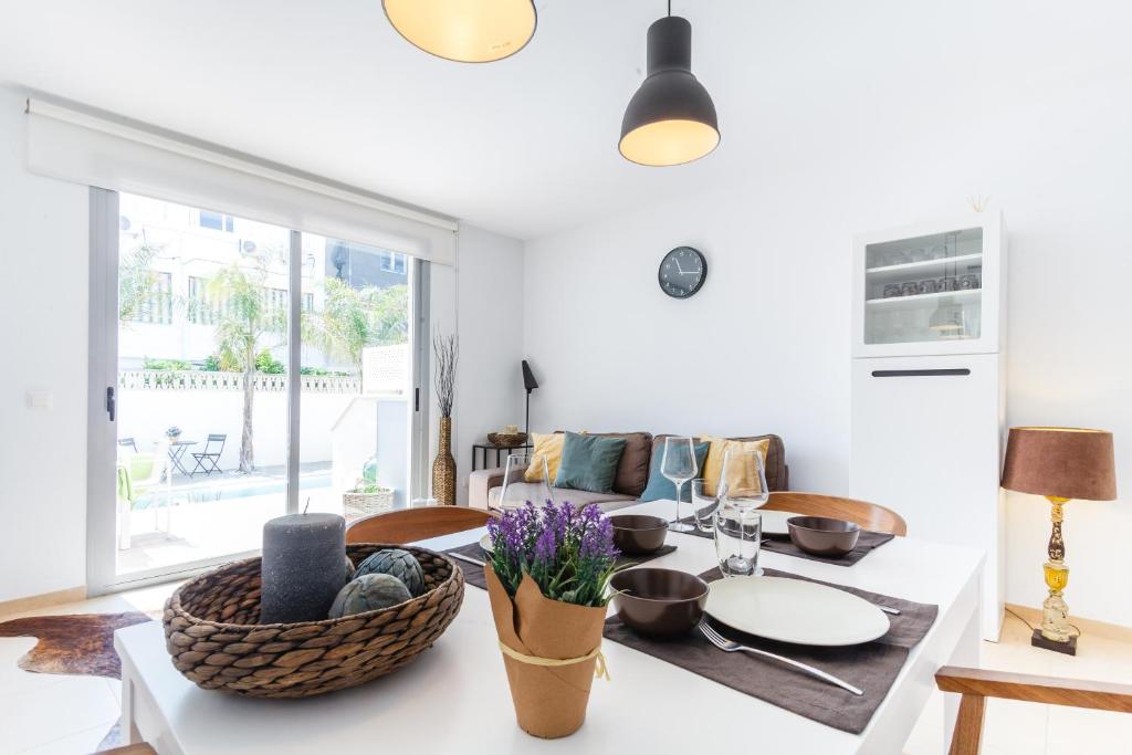 a white living room with a table and chairs at Casa Molinar in Palma de Mallorca