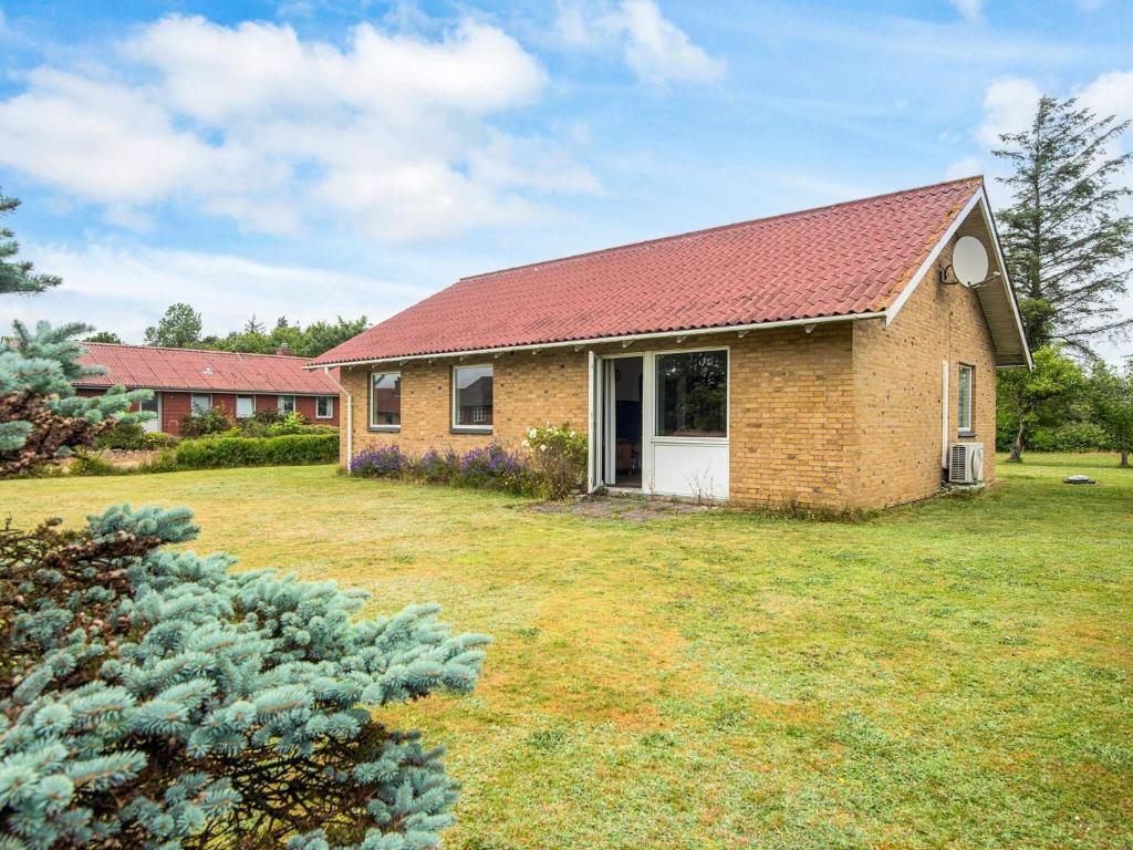 a brick house with a red roof in a yard at 5 person holiday home in Skjern-By Traum in Skjern