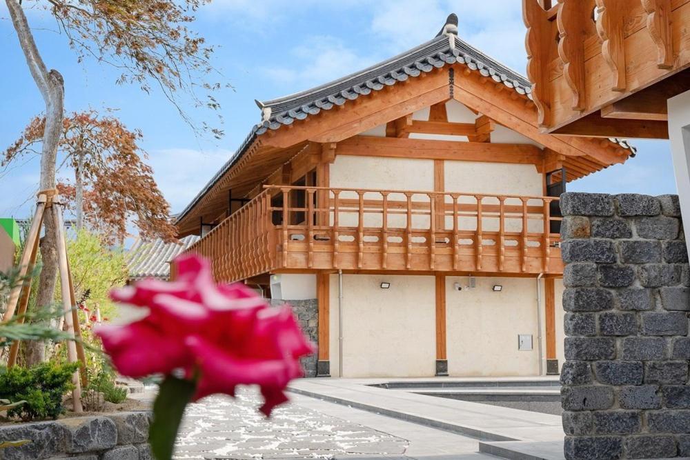 a pink flower in front of a building at Hanok Pension Wanggyeong in Gyeongju
