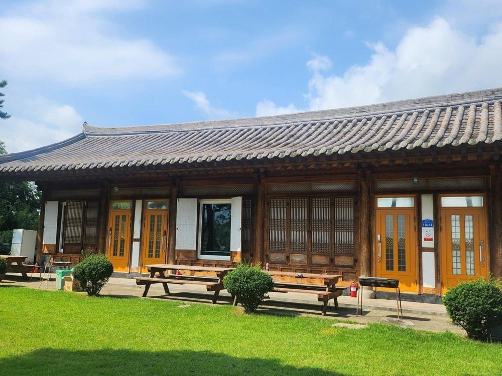 a building with benches in front of it at Unyujae Hanok Pension in Yeongam