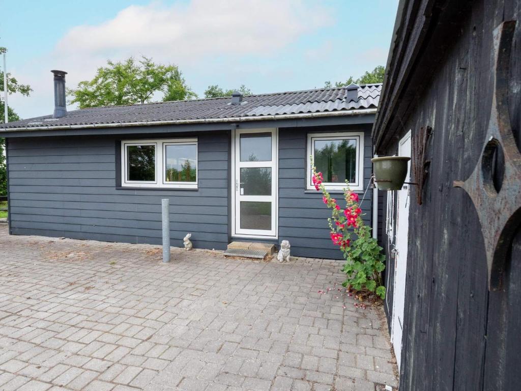 a blue house with two cats sitting outside of it at 6 person holiday home in Thyholm in Thyholm