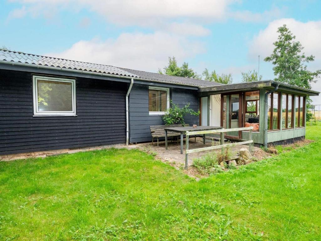 a house with a picnic table in front of it at 6 person holiday home in Thyholm in Thyholm