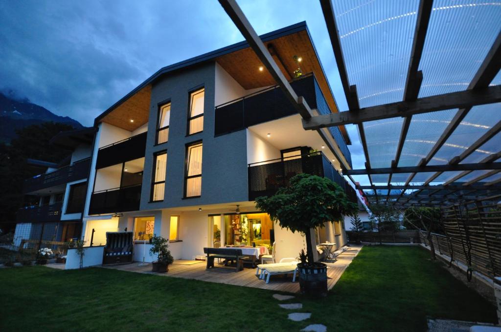uma casa grande com um telhado de vidro com um quintal em Alpenchalet Apartments em Parcines