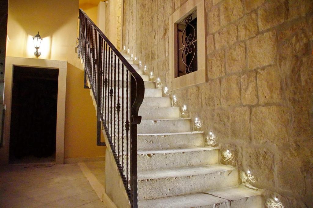 una escalera con una pared de piedra con luces. en Villa Desideria, en Split