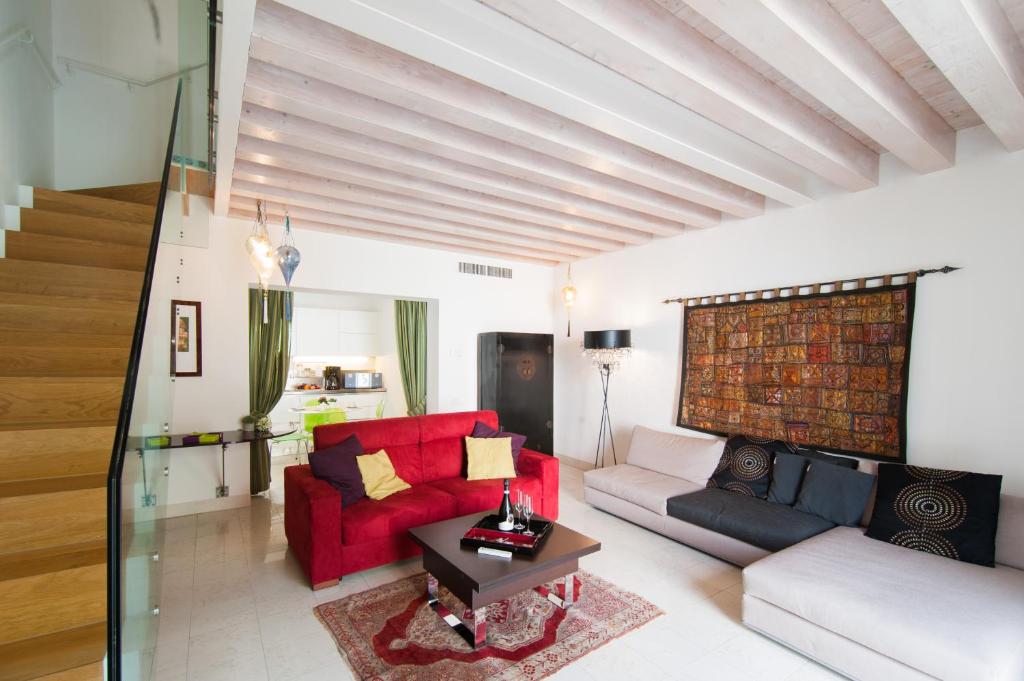 - un salon avec un canapé rouge et une table dans l'établissement Cà degli Archi, à Venise