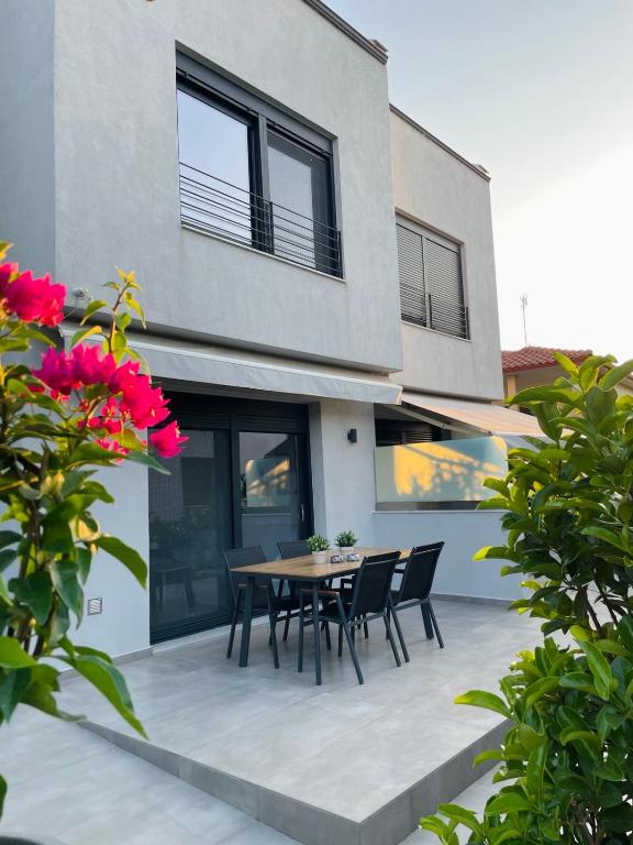 a patio with a table and chairs in front of a house at GEMINI VILLAS NIKITI in Nikiti