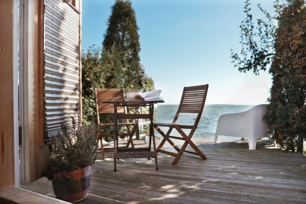 een veranda met een tafel en stoelen op het strand bij Vila Preiloja in Neringa