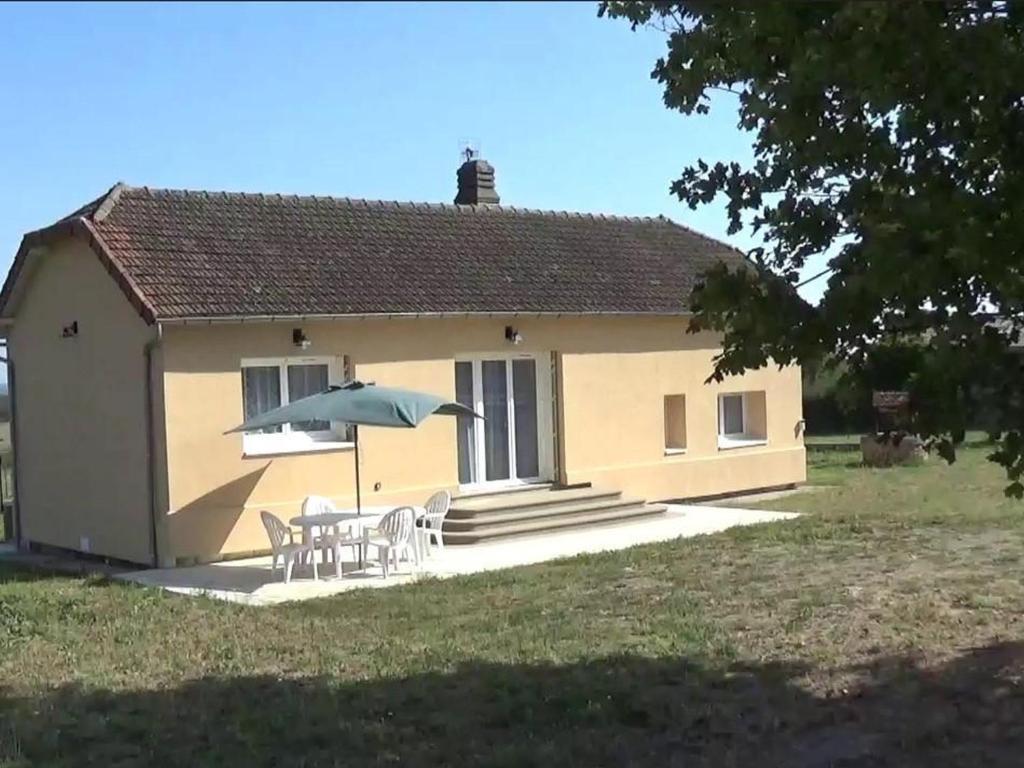 une petite maison avec une table et un parasol dans l'établissement Maison rénovée avec jardin, terrasse et Wi-Fi à Coutansouze - FR-1-489-478, à Coutansouze