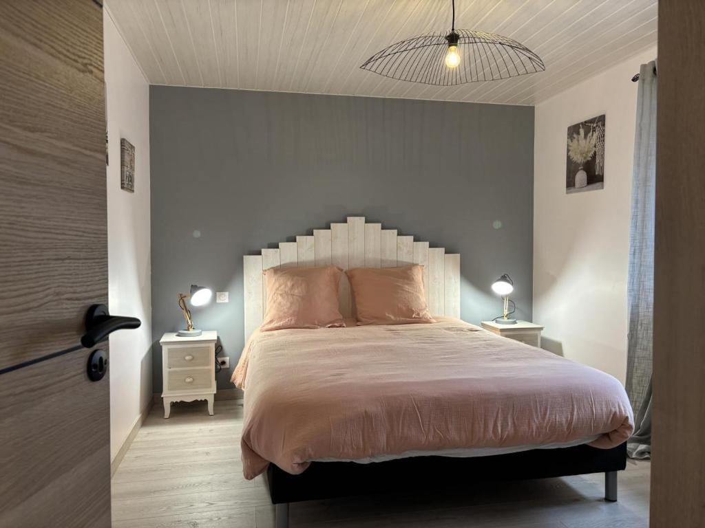 a bedroom with a large bed with pink pillows at Gîte paisible 6 pers proche Vichy et Clermont-Ferrand - FR-1-489-566 in Cognat-Lyonne
