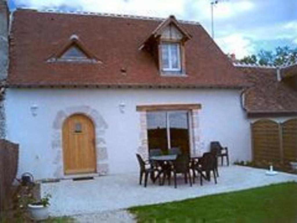 a house with a table and chairs in front of it at Maison charmante près des Châteaux de la Loire - Animaux admis - FR-1-491-407 in Cour-Cheverny