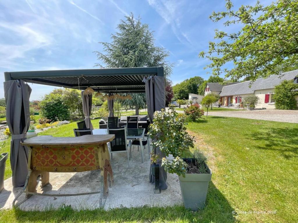 einen Pavillon mit einem Tisch im Hof in der Unterkunft Grande maison de campagne au calme avec jardin clos - FR-1-497-245 in Bocquencé