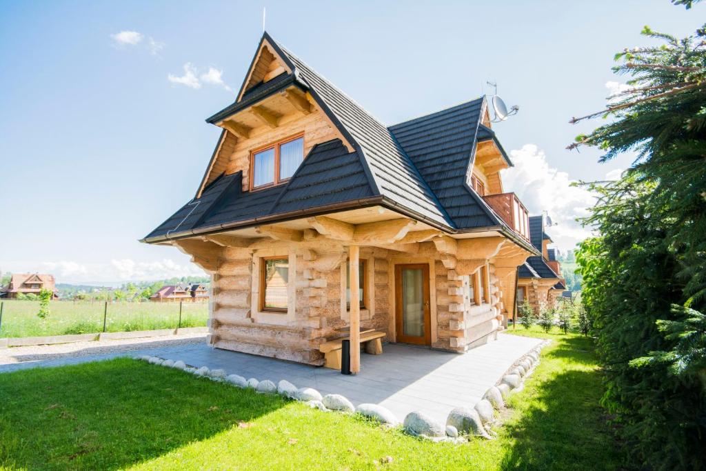 eine Blockhütte mit einem Gamerleich-Dach in der Unterkunft Domki Na Babińcu in Zakopane