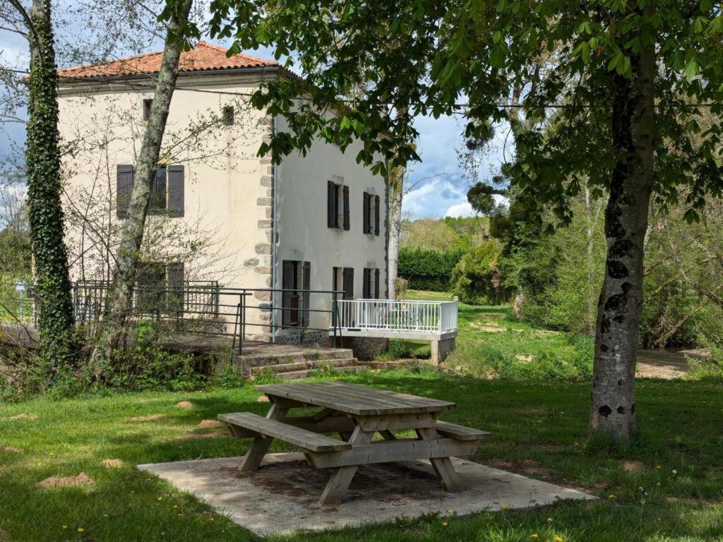 a picnic table in front of a white building at Gîte au Moulin: confort moderne avec terrasse et WIFI - FR-1-653-271 in Saint-Maurice-des-Lions
