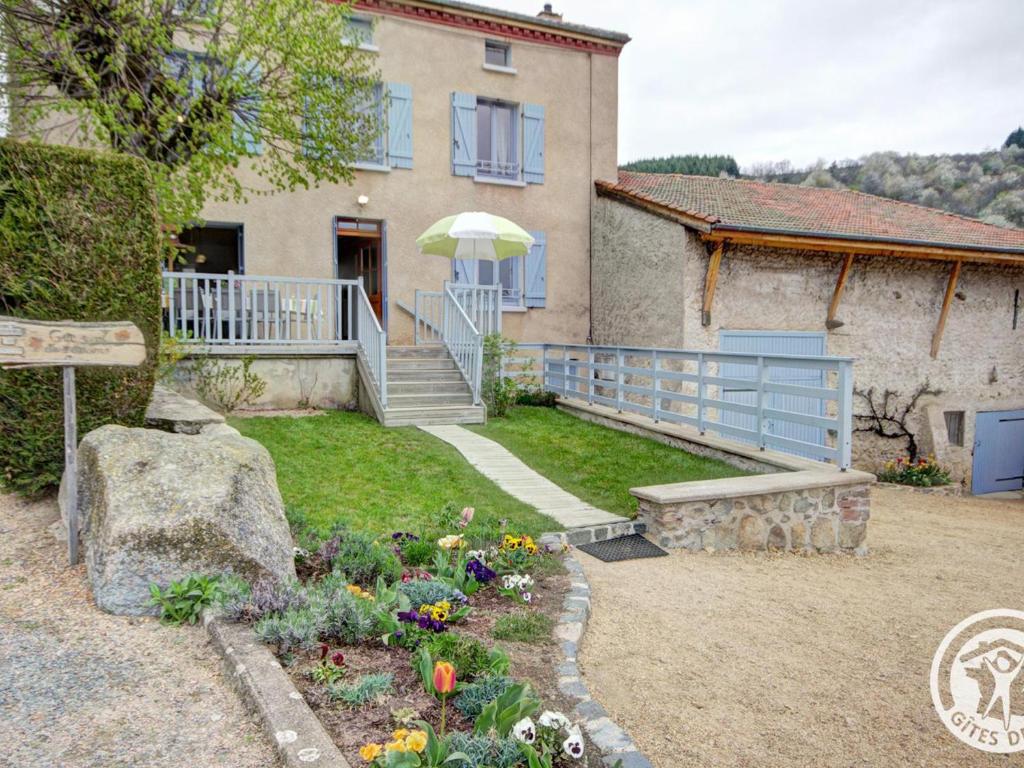 una casa con un jardín con flores en el patio en Gîte rural familial avec jardin, terrasse et équipements modernes près du Parc Livradois Forez - FR-1-496-22, en Chérier