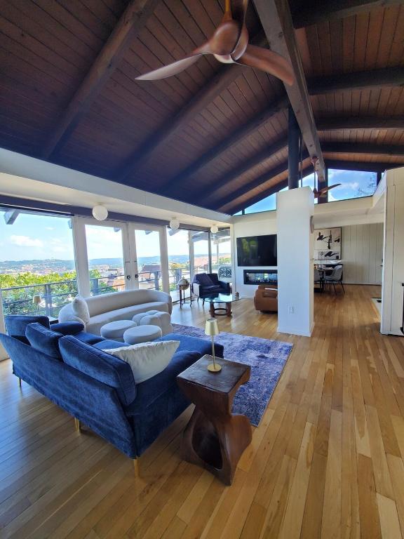 a living room with a blue couch and a ceiling fan at Luxe Mt Adams Lookout in Cincinnati