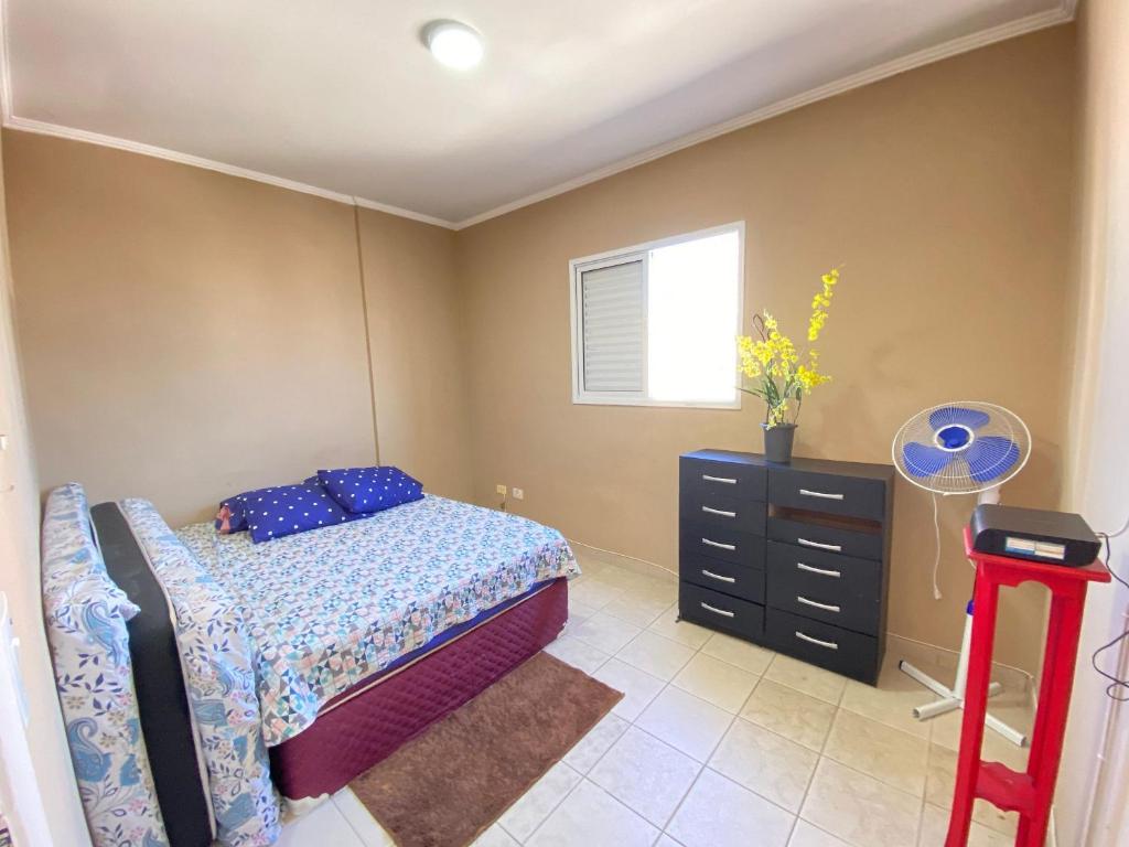 ein Schlafzimmer mit einem Bett, einer Kommode und einem Fenster in der Unterkunft Apto c/ vista mar e piscina no prédio perto do mar in Samaritá