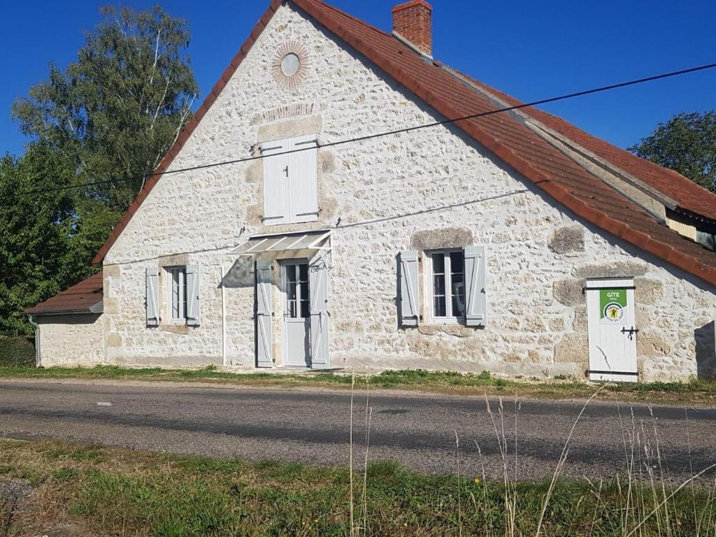 un antico edificio in pietra con tetto rosso di Maison rénovée en campagne avec jardin privé et tout confort, près de Vichy - FR-1-489-381 a Rongères