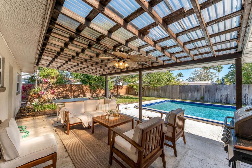 a patio with a table and chairs and a pool at 721 Java Rd in Cocoa Beach