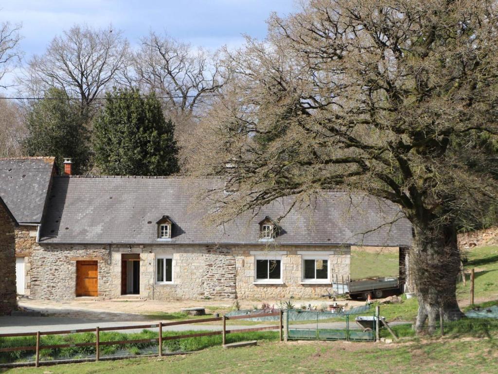 La Chapelle d'AudaineにあるMaison ancienne avec jardin, proche Bagnoles de l'Orne - FR-1-497-145の木の前の古い石造家