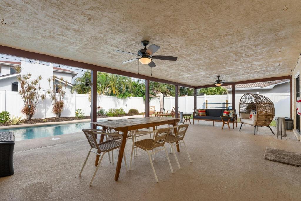 comedor con mesa, sillas y piscina en 311 Jack Dr, en Cocoa Beach