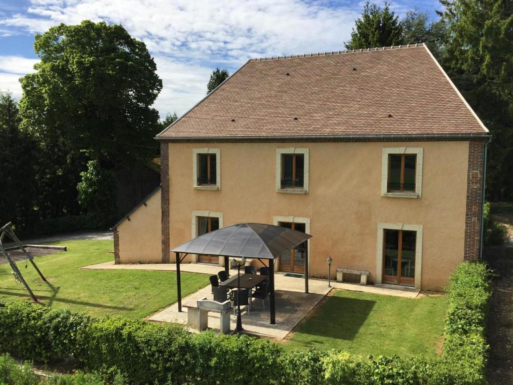 una casa con una sombrilla delante de ella en Maison familiale avec jardin clos, jeux extérieurs, wifi et tout confort au cœur du Parc du Perche - FR-1-497-10, en Feings