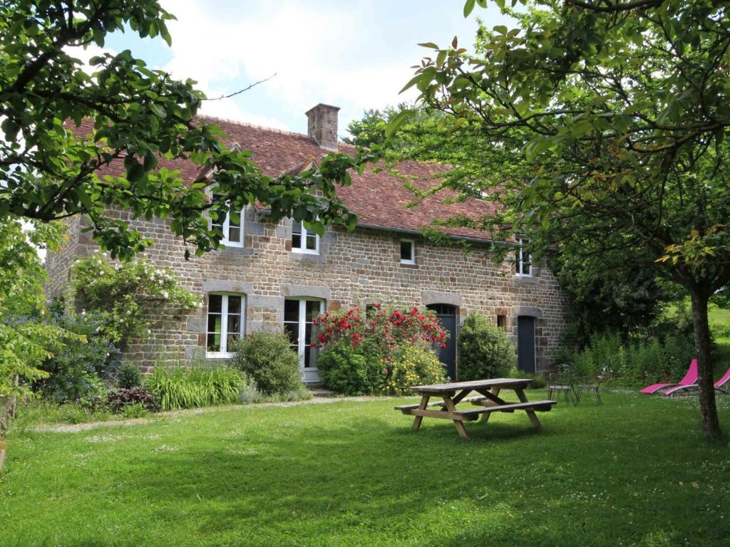 a picnic table in front of a brick house at Maison Normande : 4 Chambres, Jardin, Activités, Tout Inclus! - FR-1-497-121 in La Sauvagère