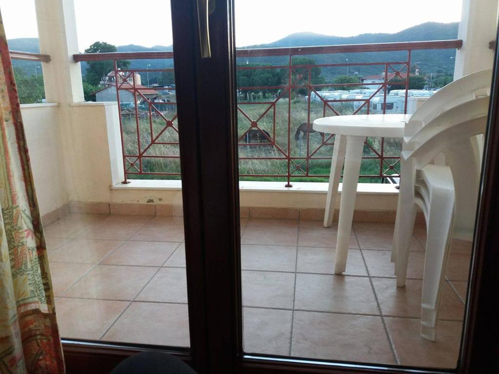 a room with a table and a balcony with a view at Hotel Kosmas in Sarti