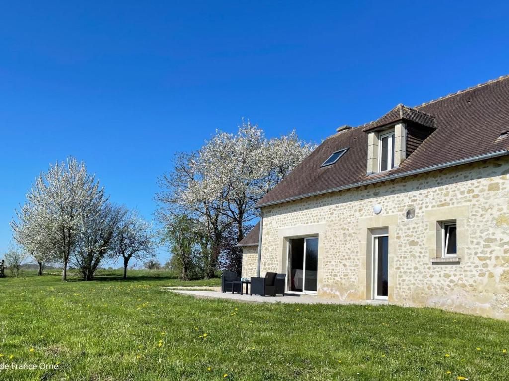 a stone house with a grass field and trees at Charmante maison en pierres restaurée, WIFI, 2 ch. - FR-1-497-241 in La Mesniere