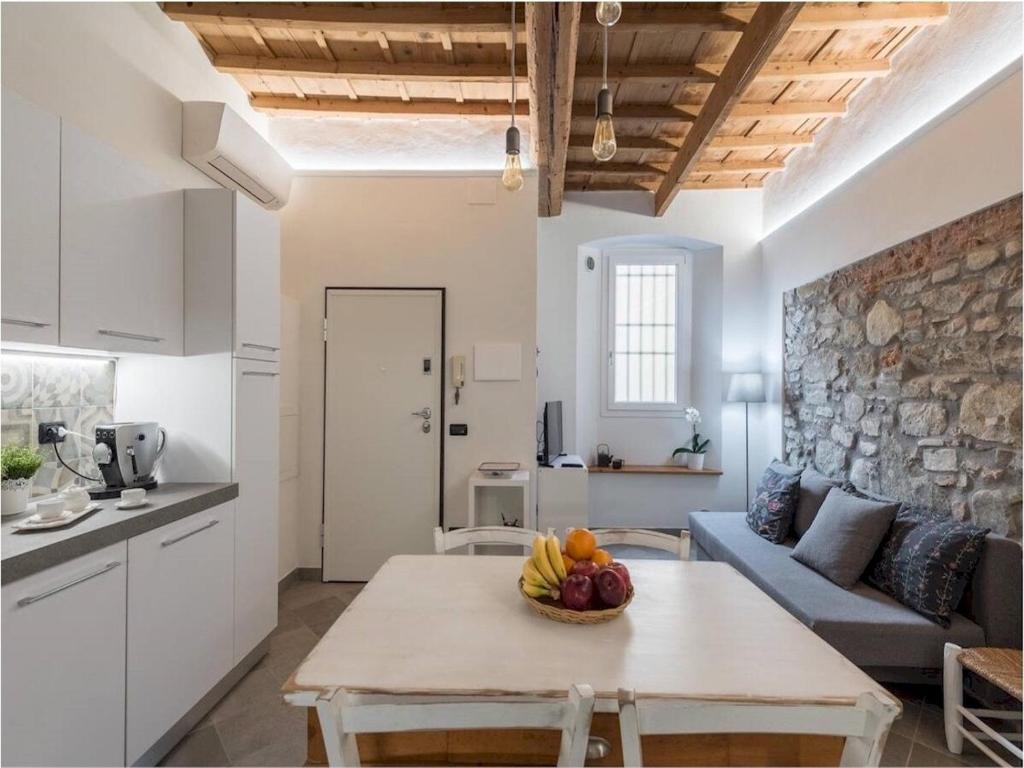 ein Wohnzimmer mit einem Tisch mit einer Obstschale darauf in der Unterkunft Interludio Fiorentino in Florenz