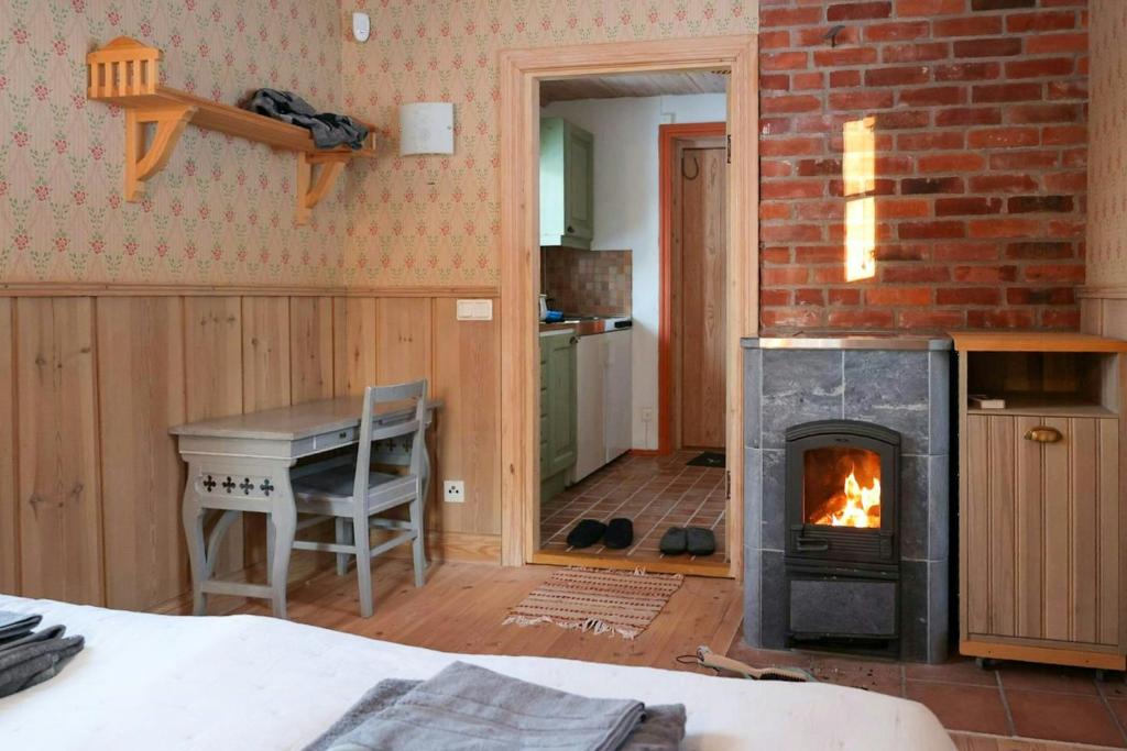 Habitación con chimenea, mesa y fogones. en Cozy Cottage By Töcksfors Lakes, en Töcksfors