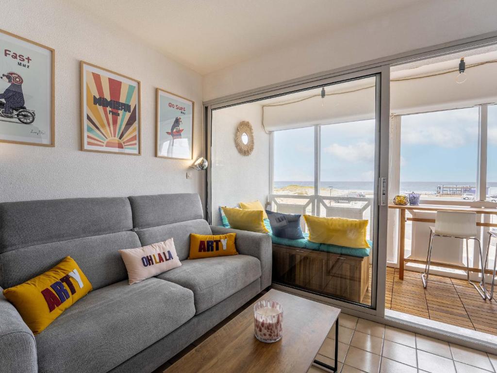 ein Wohnzimmer mit Couch und Balkon in der Unterkunft Appartement Front de Mer à Mimizan - 4 Pers, Balcon & Parking Inclus - FR-1-50-190 in Mimizan