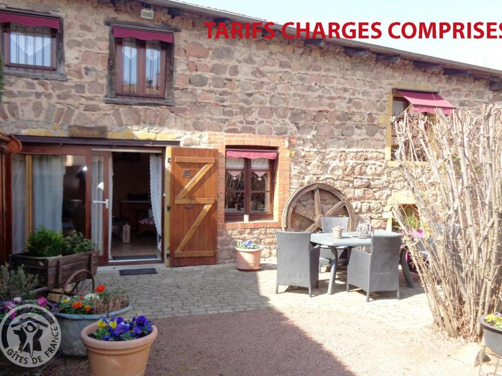 a building with a table and chairs in front of it at Gîte charmant avec jardin privatif, proche sites historiques et activités de plein air - FR-1-496-183 in Cuinzier