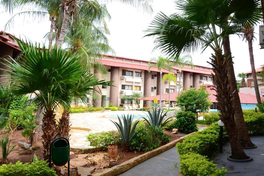 a courtyard with palm trees and a building at Recanto das Aguas Quentes in Rio Quente