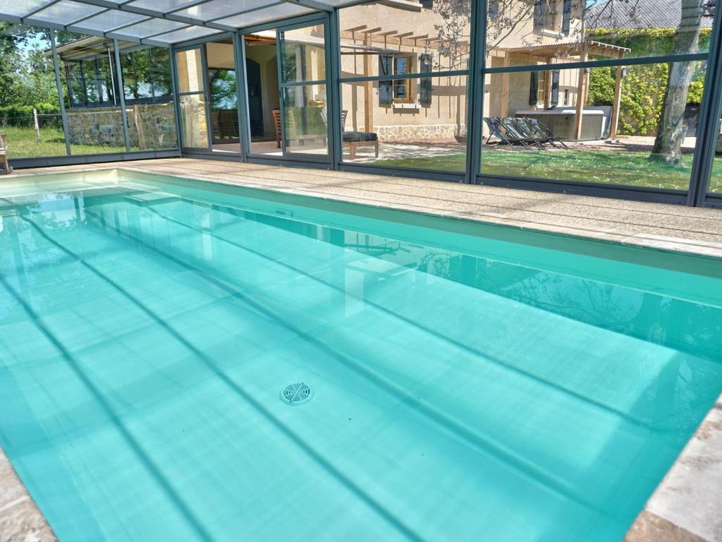 a large swimming pool with blue water at Gîte familial 14 pers. avec piscine chauffée, spa, sauna, terrains de jeux et borne électrique. - FR-1-496-3 in Vivans