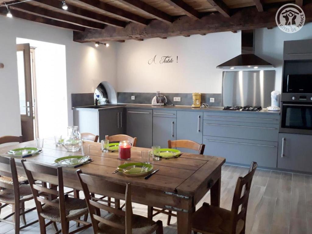 a kitchen with a wooden table and a dining room at Gîte charmant à la ferme, tout confort, proche de Roanne, idéal pour randonnées et baignades - FR-1-496-220 in Crémeaux