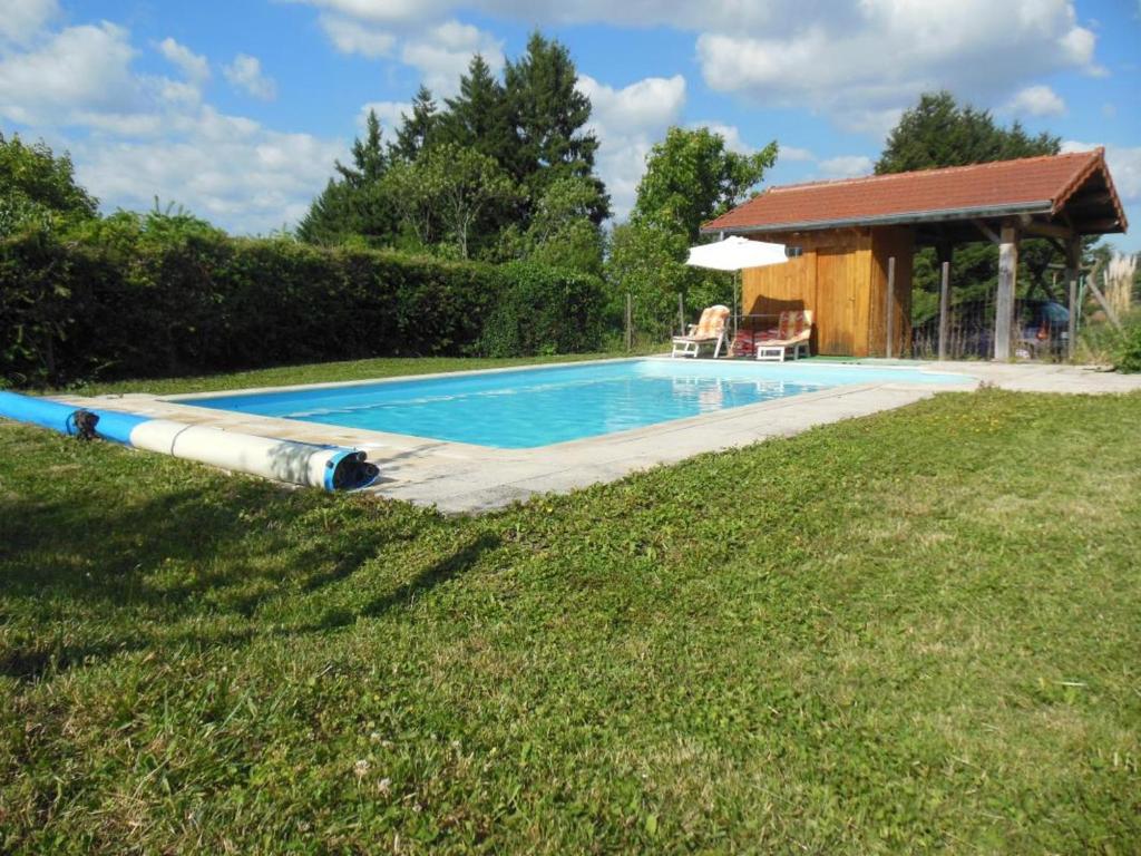 a swimming pool with a large tube next to a house at Gîte spacieux à Renaison avec cheminée, jardin et équipements enfants - FR-1-496-257 in Renaison