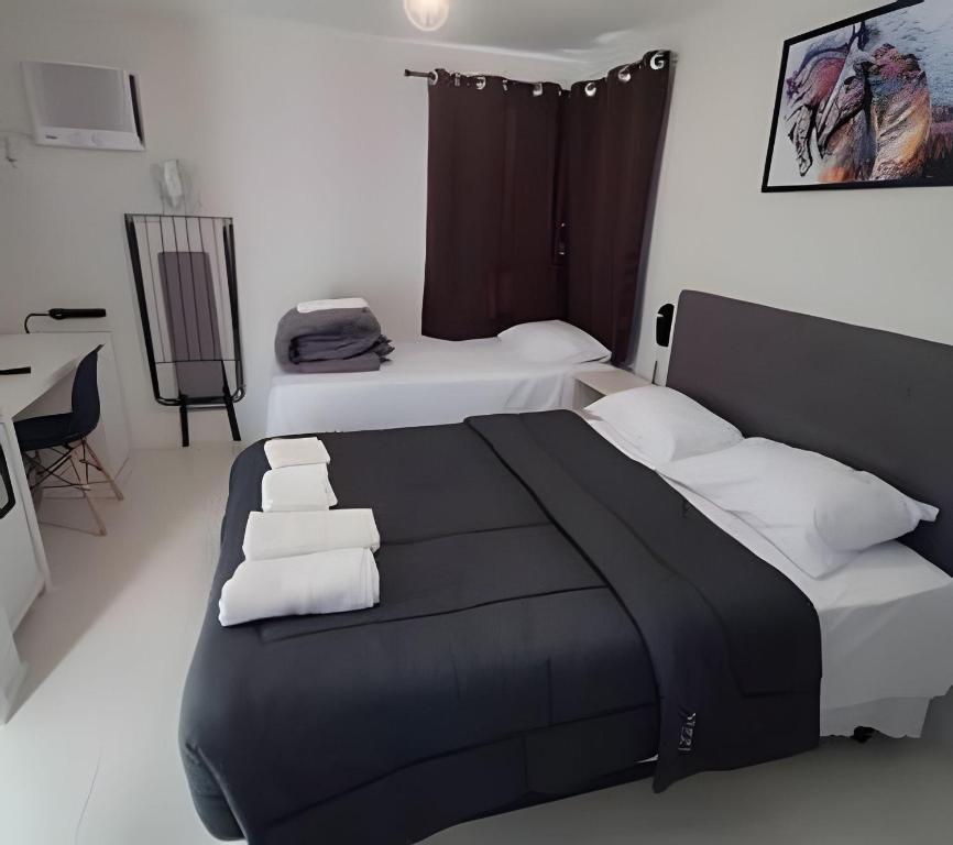 Un dormitorio con una cama grande con almohadas blancas. en Apartamento Excelente Liberdade SP, en São Paulo