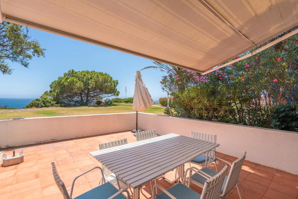 a patio with a table and chairs and an umbrella at Ocean Villa Algarve in Alvor