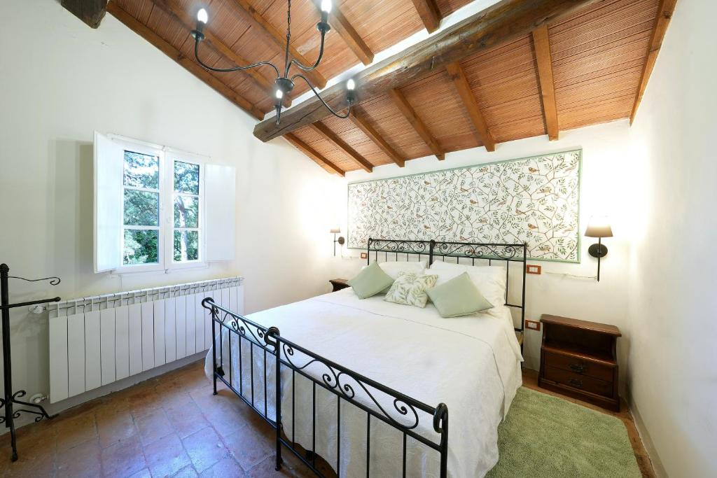 a bedroom with a bed and a window at Historic Villa Overlooking Lake Trasimeno in Paciano
