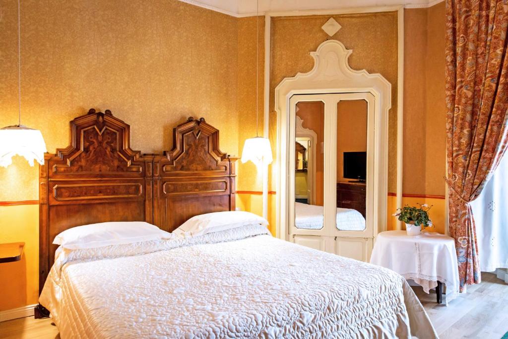a bedroom with a large bed and a large mirror at Antica Locanda Solferino in Milan
