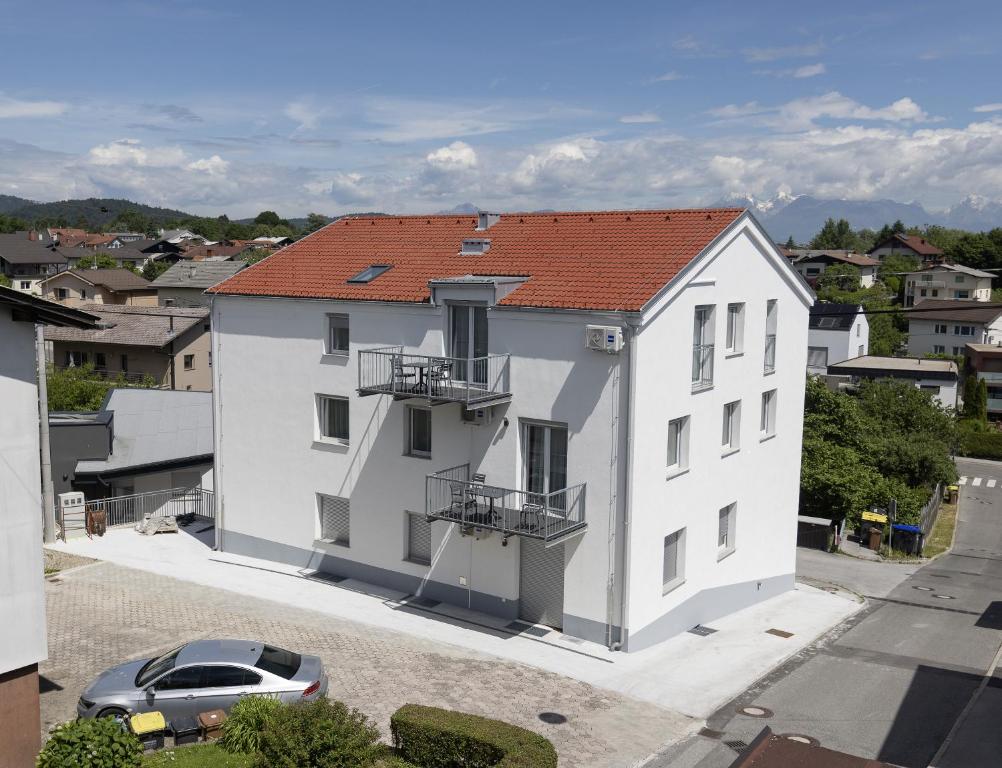 a white apartment building with a red roof at Villa Andrea Apartments - Ljubljana in Ljubljana