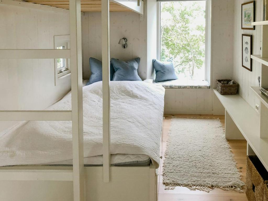 a bedroom with a bunk bed and a window at Family Cabin By The Sea With Private Pier in Ula
