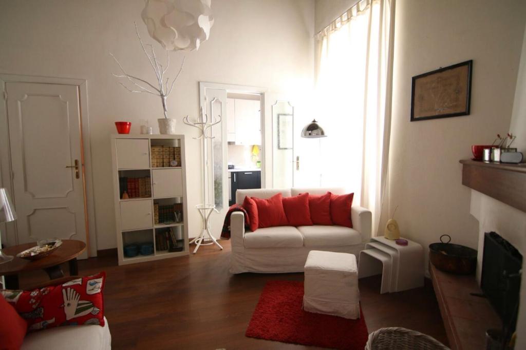 salon z białą kanapą i czerwonymi poduszkami w obiekcie Cosenza Vecchia: arte & storia w mieście Cosenza
