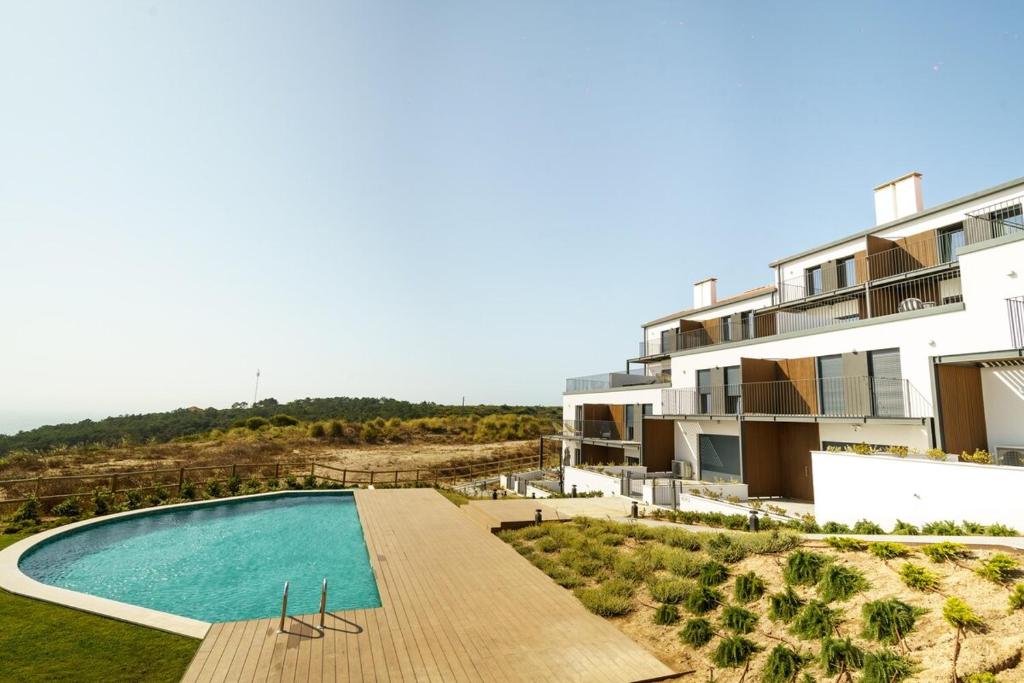 een appartement met een zwembad voor een gebouw bij Ocean Breeze Retreat near Ericeira in Carvoeira