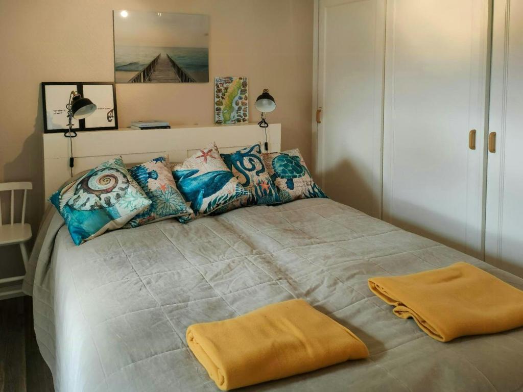 une chambre avec un grand lit avec des oreillers colorés dans l'établissement Newly Renovated Cottage With Sea View In Säckebäck, à Varekil