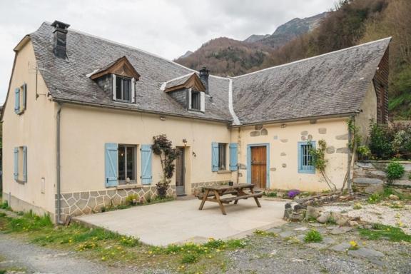 une maison avec une table de pique-nique devant elle dans l'établissement Chez Louise, à Cauterets