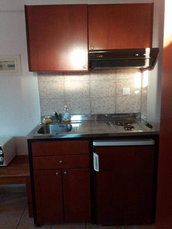 a kitchen with a sink and a stove at Hotel Kosmas in Sarti