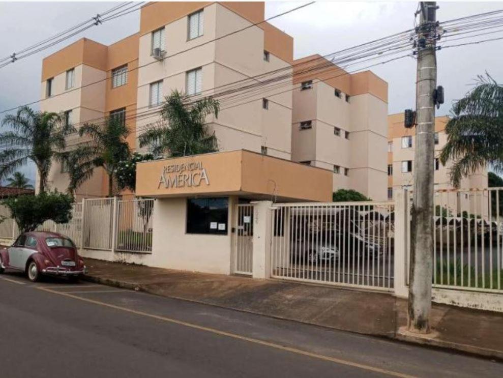 a red car parked in front of a building at Excelente e amplo Apto 2 Q in Araguari